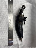 Khukri in scabbard beside ruler showing length