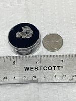 Crystals in display case beside ruler and coin for scale