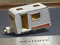 Side view showing white ribbed body, orange stripe, opening yellow door, silver hitch