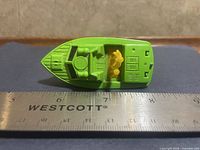 Top view showing green deck, yellow figure, interior details, ruler for length reference