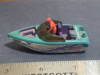 Left side view of Matchbox ski boat showing hull graphics, driver figure, and scale with ruler