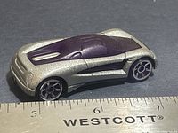 Left side view of silver and purple Hot Wheels car next to ruler