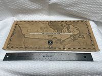 Front of brown map-design folder reading Millennium Canada 1999 with ruler for scale