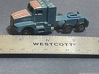Left side view of Novacar die-cast semi truck beside ruler for scale