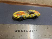 Left side view of yellow Playart Corvette Sting Ray with ruler for scale