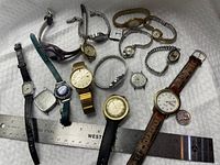 Group shot of all 13 Timex watches with ruler for scale
