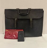 Front view of black leather briefcase, red pouch and black key case