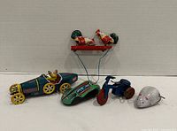 Group shot of all five tin wind-up toys