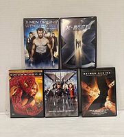 Group shot of five DVD cases: X-Men Origins: Wolverine, X-Men, Spider-Man 2, X-Men: The Last Stand, Batman Begins
