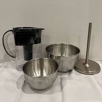 Pitcher, two nesting stainless steel bowls and paper towel holder arranged together