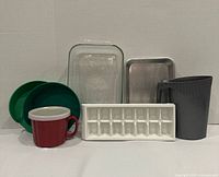 Group photo of glass baking dish, metal tray, ice cube tray, milk bag pitcher, soup mug with lid, two green scrap trays