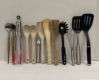 Front view of all 13 utensils standing upright in a row
