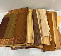 Stack of mixed wood veneer sheets showing varied species and grain