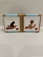 Front view of two boxed felt toy sewing kits showing kitten and puppy projects