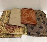 Four folded fabric remnants showing patterns and colours