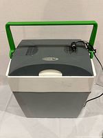 Front view of grey/white Mobicool portable cooler with green handle