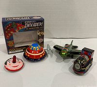 Front view of all tin toys and box