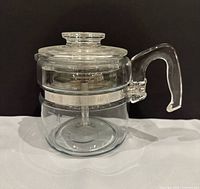 Percolator assembled showing glass body, lid, handle, metal band
