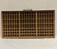 Front view of wooden printers type drawer showing compartment grid