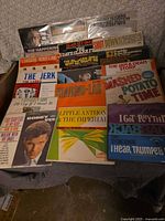 Box of assorted vinyl records showing multiple album covers