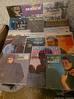 Stack of 12" vinyl records inside box showing multiple album covers