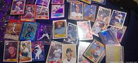 Overhead view of assorted sleeved and unsleeved baseball cards on a dark surface