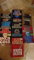All seven Clive Cussler hardcover novels laid out