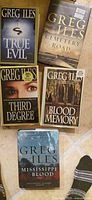 Group shot of all five Greg Iles novels arranged on tiled floor