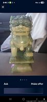 Front view of jade resin foo dog statue showing facial features, chest ornament and base.