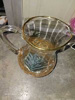 Clear glass pitcher with gold rim, amber base, painted leaves
