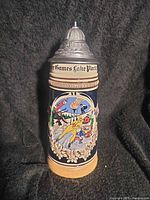 Full view of stein front showing relief artwork and lid