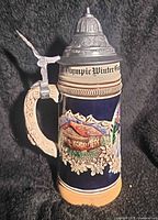 Front view showing chalet scene, edelweiss flowers, pewter lid and thumb lift