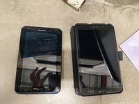 Front view of two Samsung tablets, left screen cracked, right in case