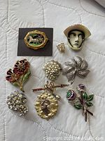 Front view of all ten brooches arranged on quilted fabric