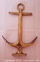 Full view of brass anchor andiron front