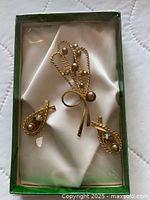 Set in box showing brooch and earrings on satin lining