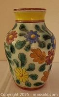 Front view of ceramic vase showing floral motif and yellow neck