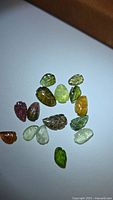 Group of multicoloured leaf-cut tourmaline gemstones shown on white background