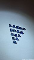 Group of square blue sapphires arranged in a triangle pattern