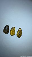 Three cognac colored leaf-cut tourmalines on white background