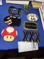 All seven metal belt buckles displayed on blue surface