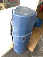 Full view of blue hard plastic golf travel case standing upright