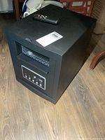 Full view of black cabinet heater showing vent, control panel, dimensions sticker