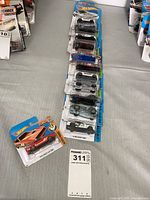 Stack and single display of multiple sealed Hot Wheels blister packs
