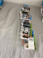 Row of twelve Hot Wheels blister-carded cars arranged face-up
