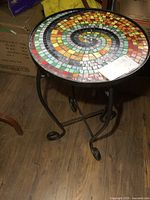 Top view of round table showing multicolour spiral glass mosaic and metal rim