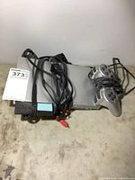 Top view of silver PS2 console, controller, and bundled cables