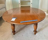 Top view of oval coffee table showing one leaf seam and turned legs