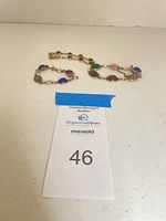 Lot overview showing two of the three gold-tone scarab link bracelets