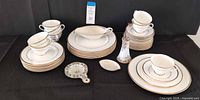 Overall lot showing plates, cups, Lenox gravy, spoon rest, tea strainer, Nippon holder